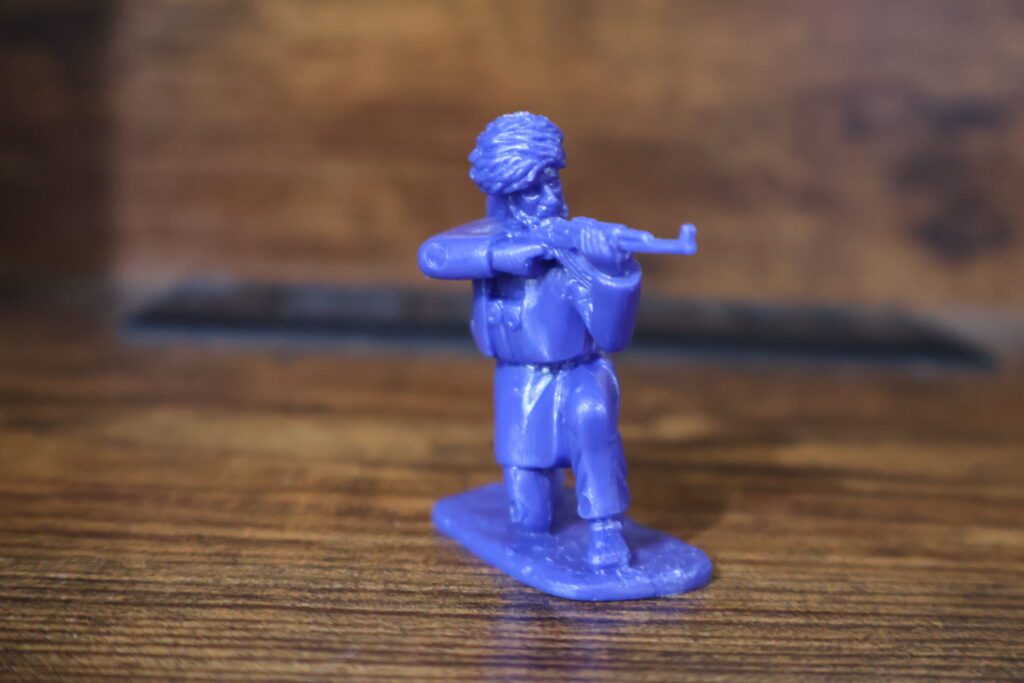 crouching blue toy soldier with rifle